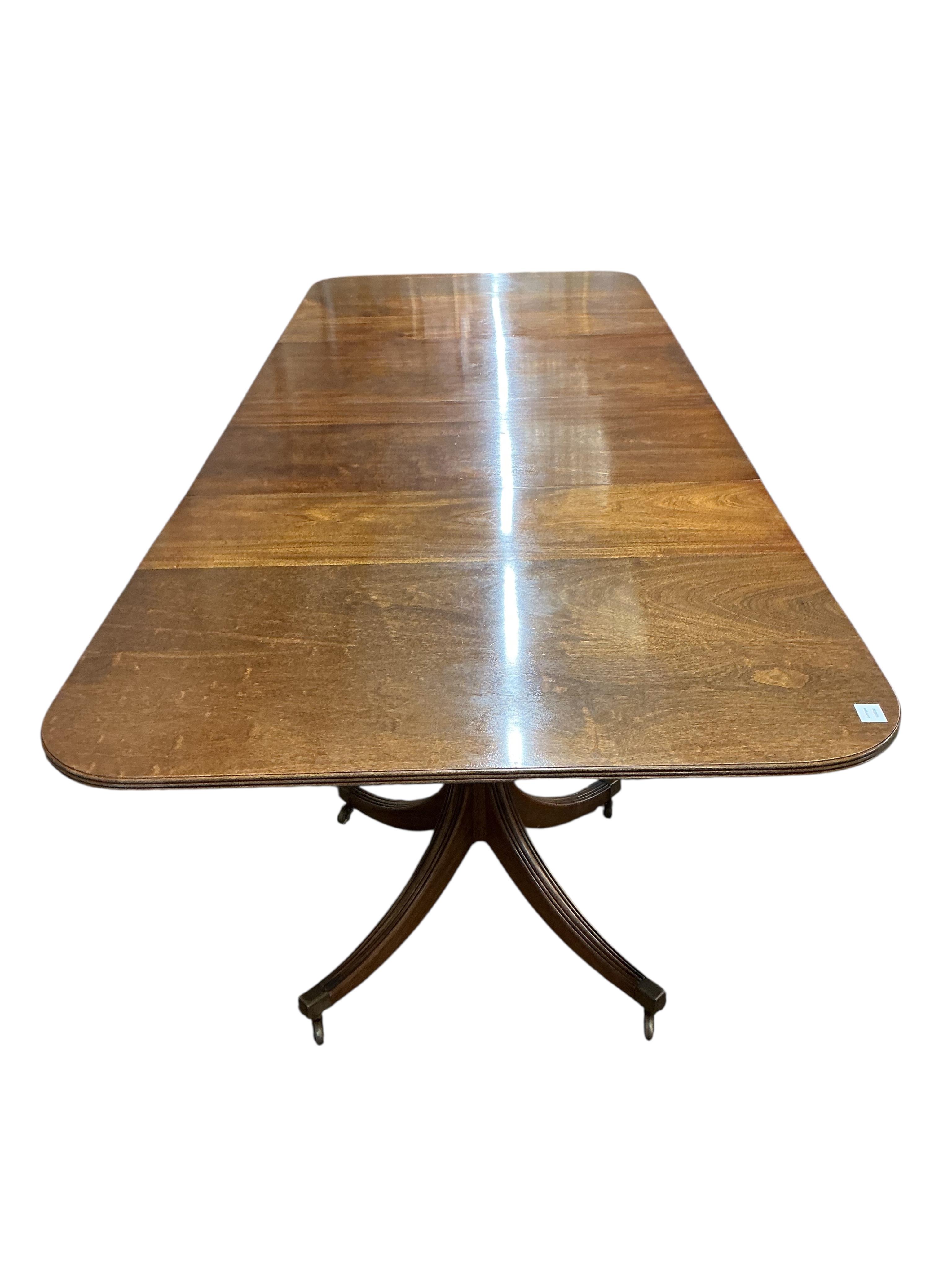 A Regency style mahogany twin pillar extending dining table, width 295cm extended, two spare leaves, depth 114cm, height 74cm